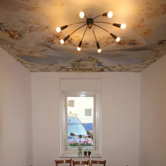 Der leere Gastraum mit langem Holztisch, Stühlen und Fenster zur Straße