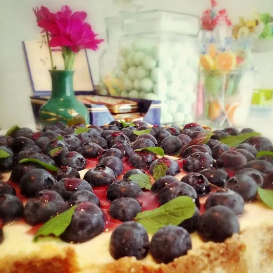Ein Blechkuchen mit Weintrauben und Minzblättern, im Hintergrund bunte Gläser